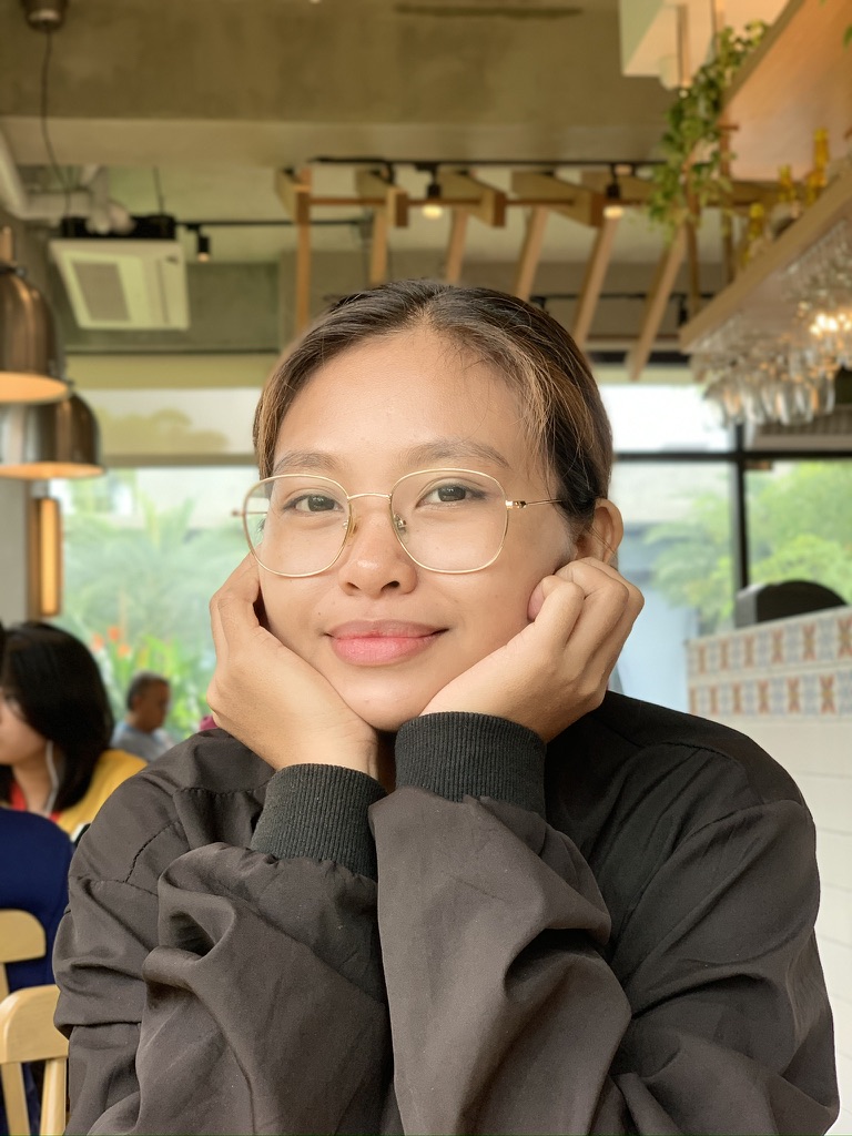 Yolyn resting her chin on her hands at a caf&eacute;